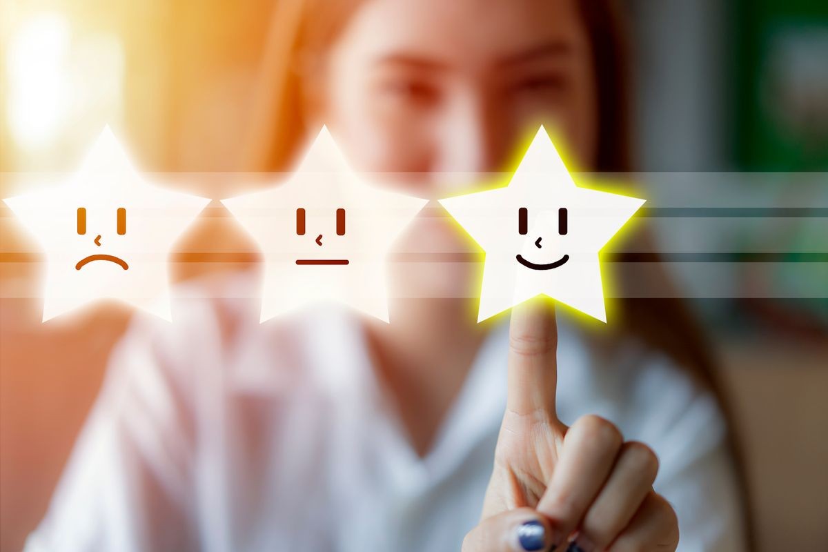 Hand of client show a feedback with smiley face or Asian Business Woman pressing stars face emoticon on virtual touch screen. Service rating, satisfaction, Customer service evaluation concept.